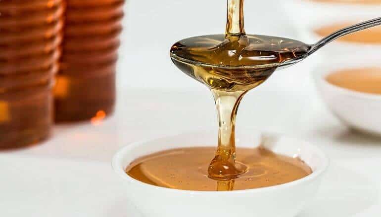 pouring honey over a spoon