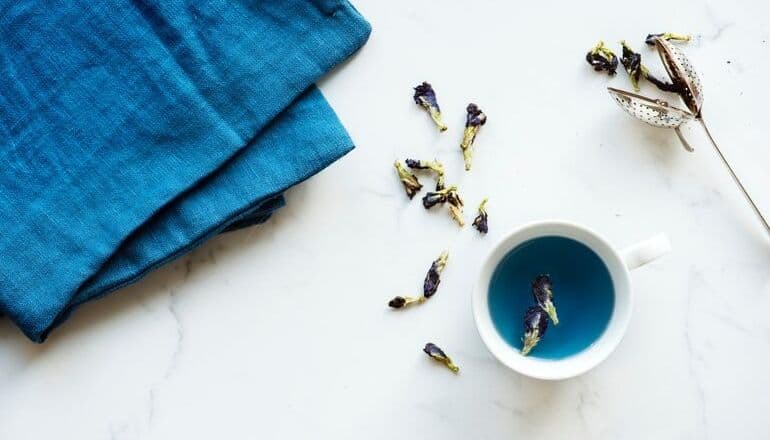 blue tea in a cup on table. One of the best Herbal Flower Teas