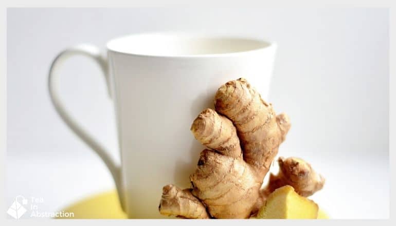 ginger tea with a slice of lemon and a piece of ginger root next to it