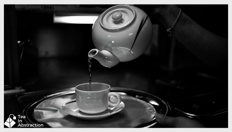 cup of tea being poured from a kettle