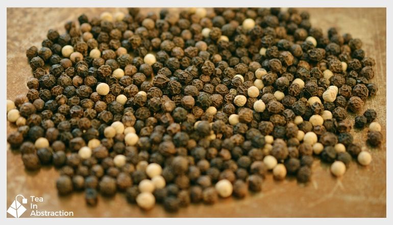 pile of black peppercorns on a table