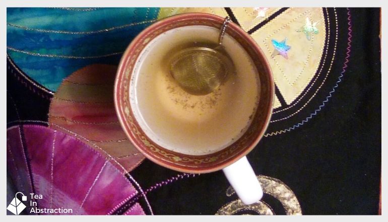 cup of thyme tea with an infuser resting in the water